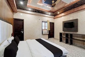 A hotel room with a large bed, a flat-screen TV, and a ceiling with a decorative pattern. - Hotel O Aurivique hotels and Banquets (Lucknow)