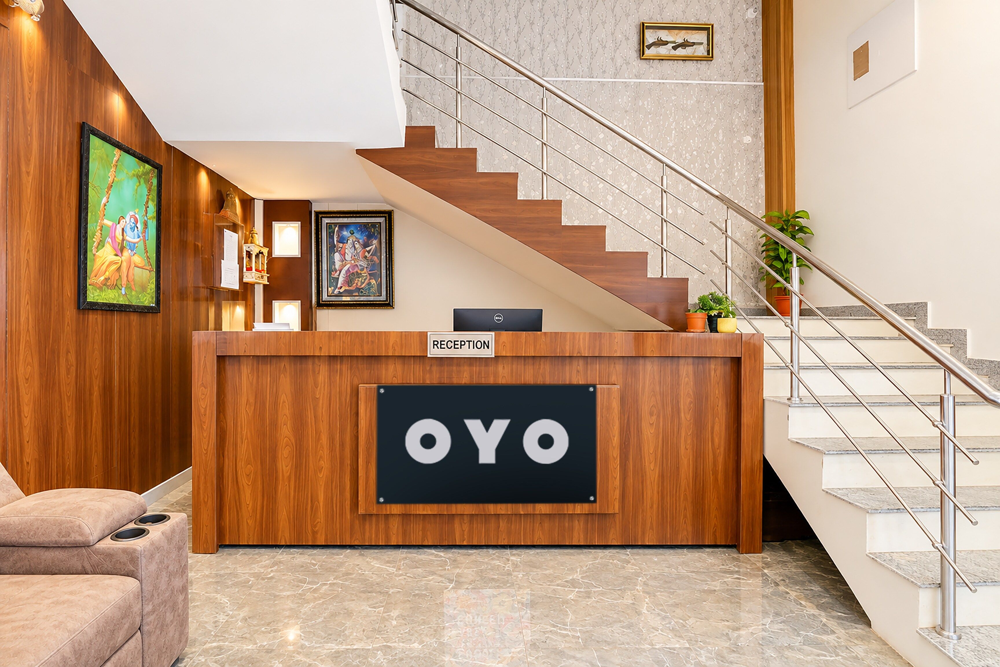 A reception desk with a sign that reads 'OYO' and a staircase with a metal railing.
