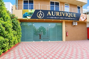 A hotel entrance with a sign reading 'AURIVIQUE HOTELS AND BANQUETS' and a tree graphic on the door. - Hotel O Aurivique hotels and Banquets (Lucknow)