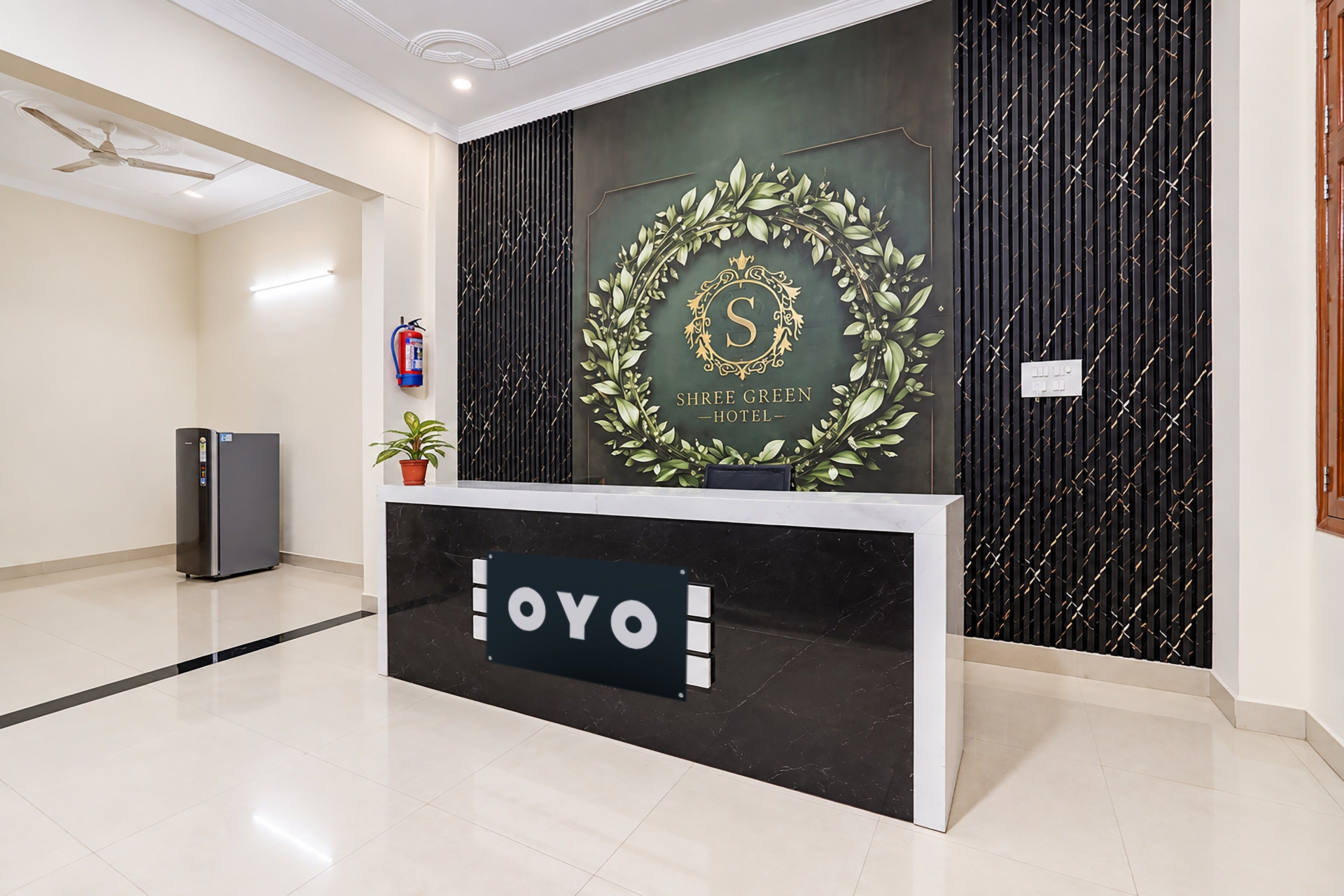 En receptionsdisk med en skylt som visar texten ”OYO HOTEL” och en dekorativ symbol ovanför.