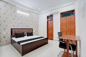 A bedroom with a bed, a desk, and a wardrobe. - Hotel O The Sukoon House (Lucknow)