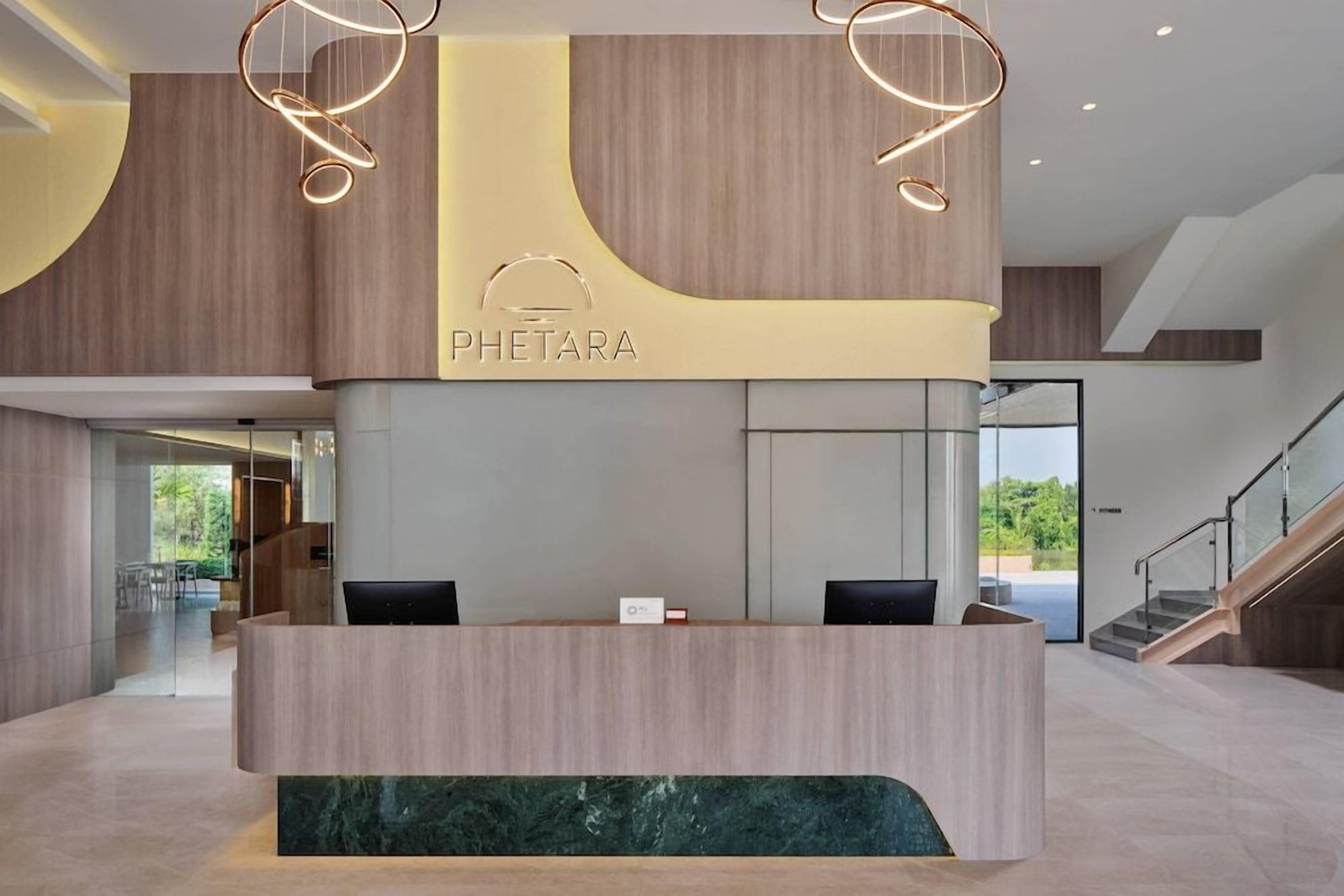 A reception desk with a modern design, featuring a wooden finish and a marble accent.