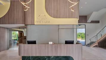 A reception desk with a modern design, featuring a wooden finish and a marble accent.