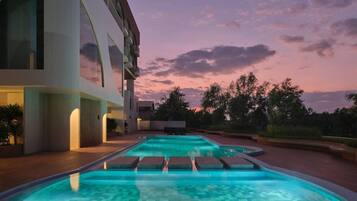 Un edificio moderno con piscina y zona de estar al aire libre.