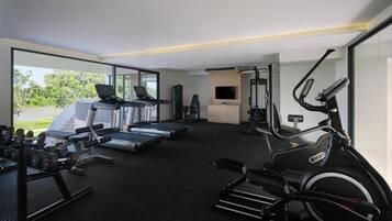 A modern gym with treadmills, a stationary bike, and weight machines.