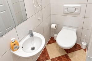 A bathroom with a sink, toilet, and a hand soap dispenser. - Your Vienna Encore 1BR near Stadthalle (Vienna)