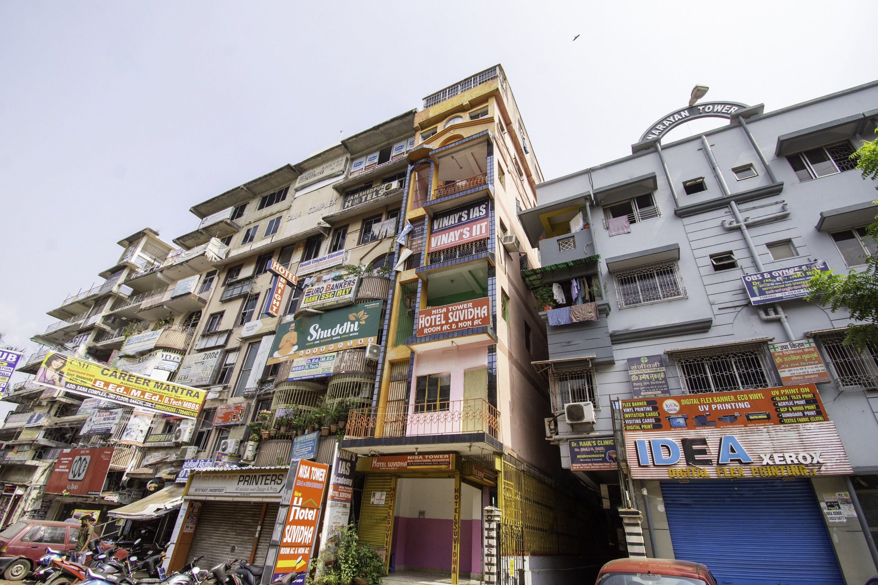 A multi-story building with various commercial establishments including a hotel, a printing shop, and a bank.