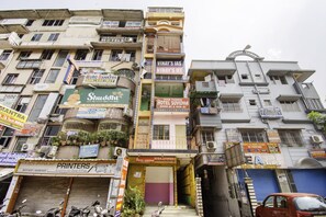 A multi-story building with various commercial establishments, including a hotel, a bank, and a printing service.