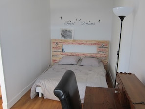 A bedroom with a bed, a desk, and a lamp. - New Listing (REIMS)