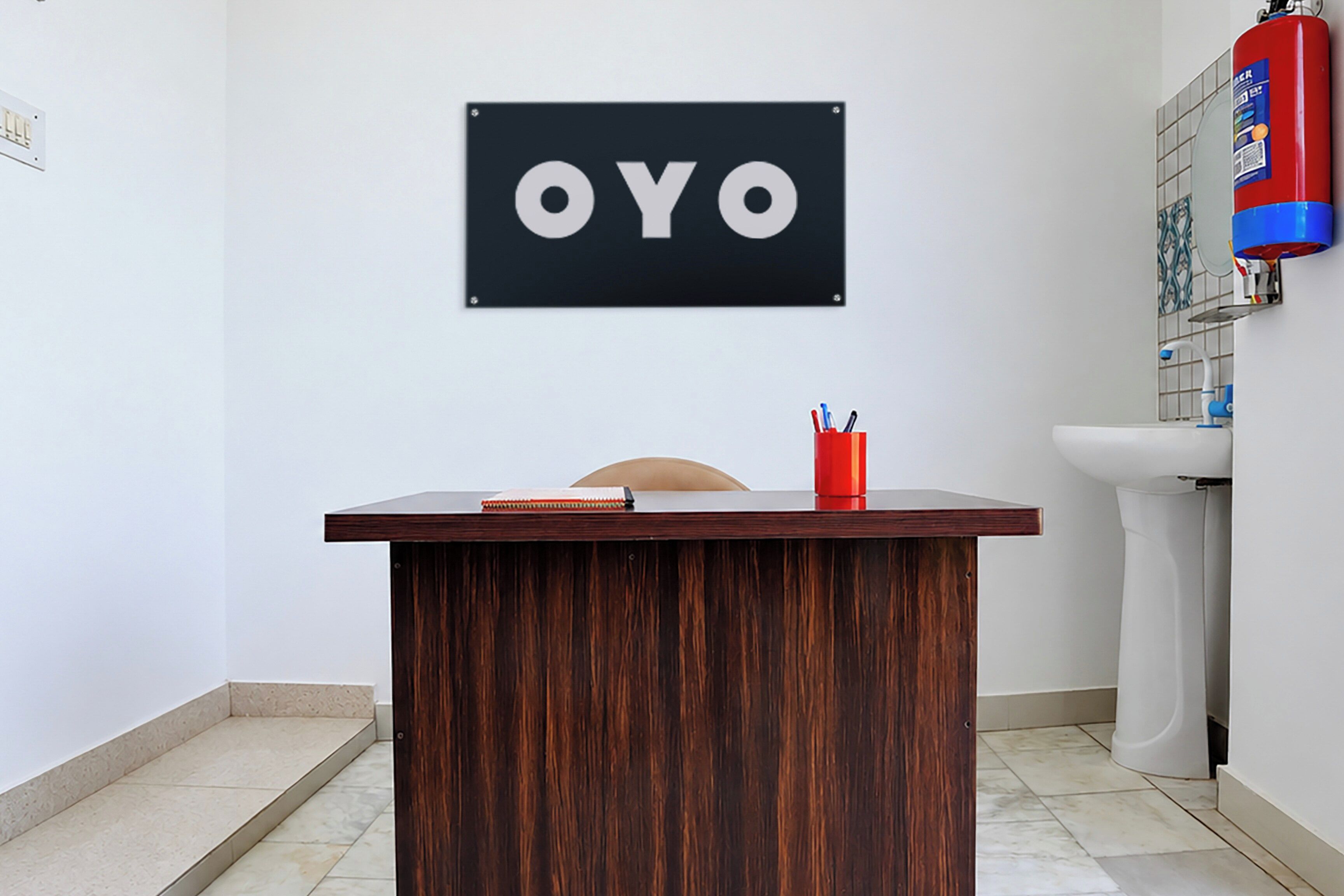 A reception desk with a sign that reads 'OYO' mounted on the wall.