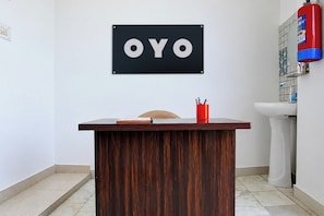 A reception desk with a sign that reads 'OYO' mounted on the wall. - HOTEL O AAVYA INN (Lucknow)