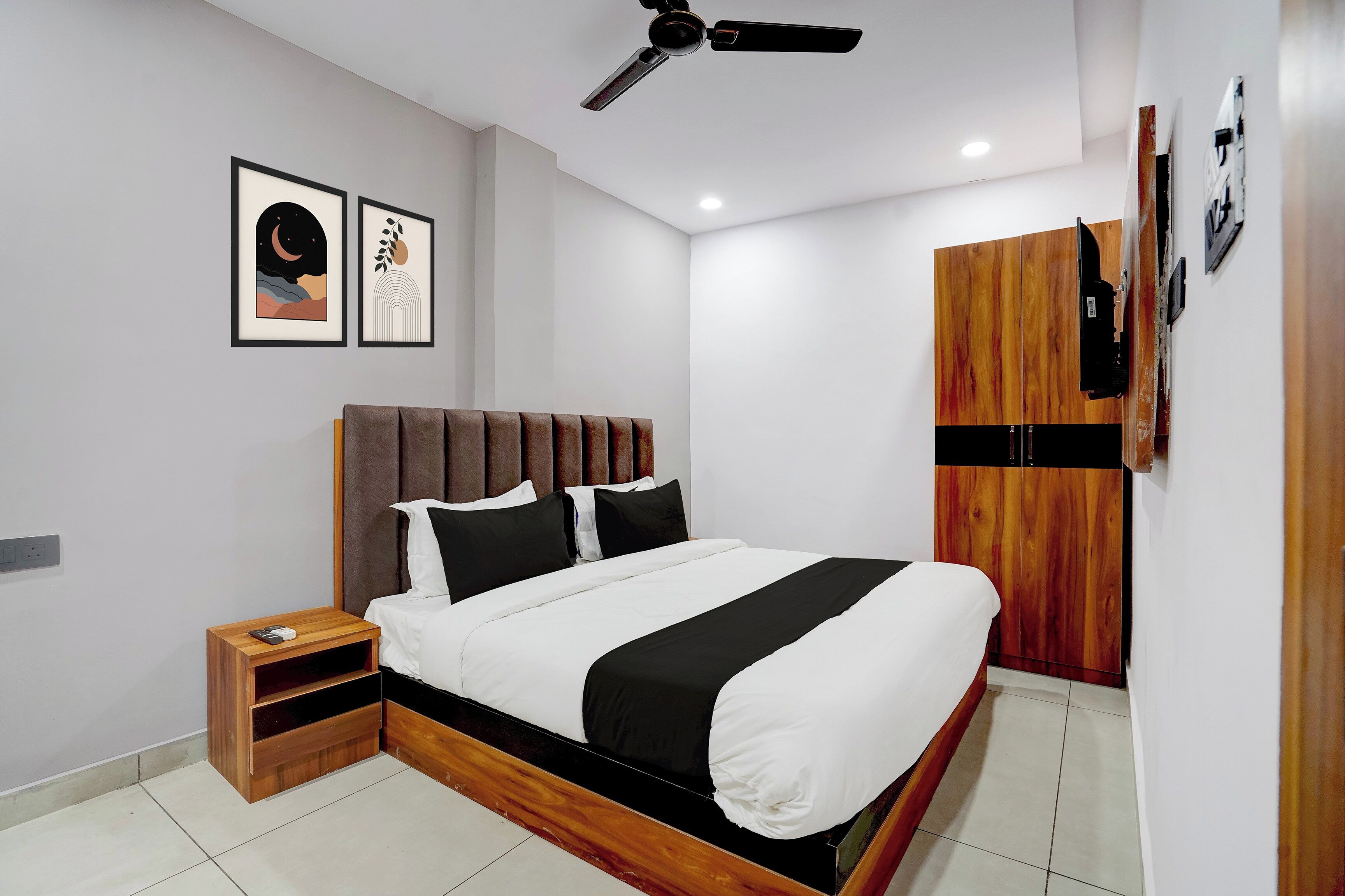 Un dormitorio moderno con cama, mesita de noche, armario y ventilador de techo.