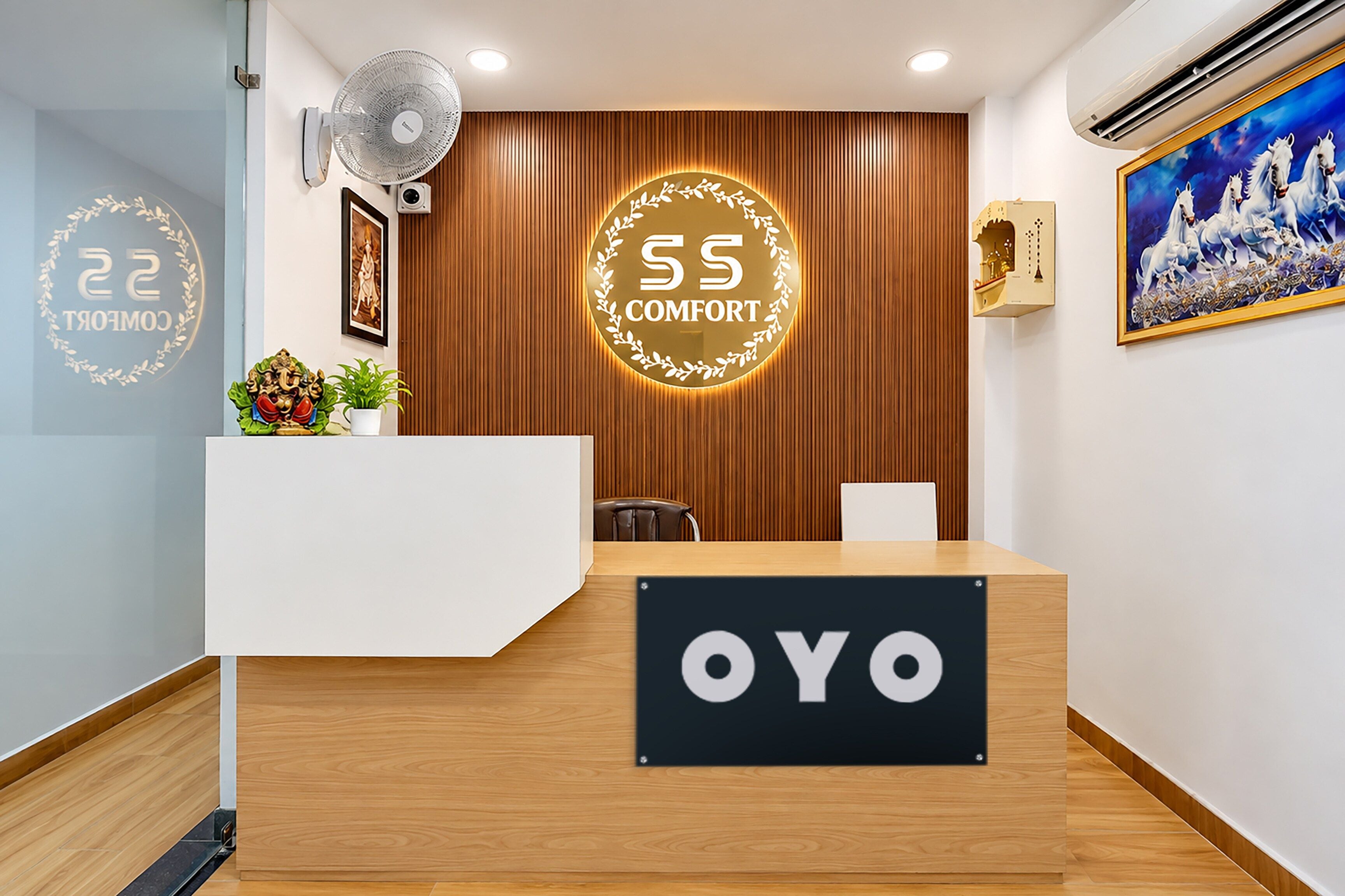 A reception desk with a sign that reads 'SS COMFORT' and 'OYO'.