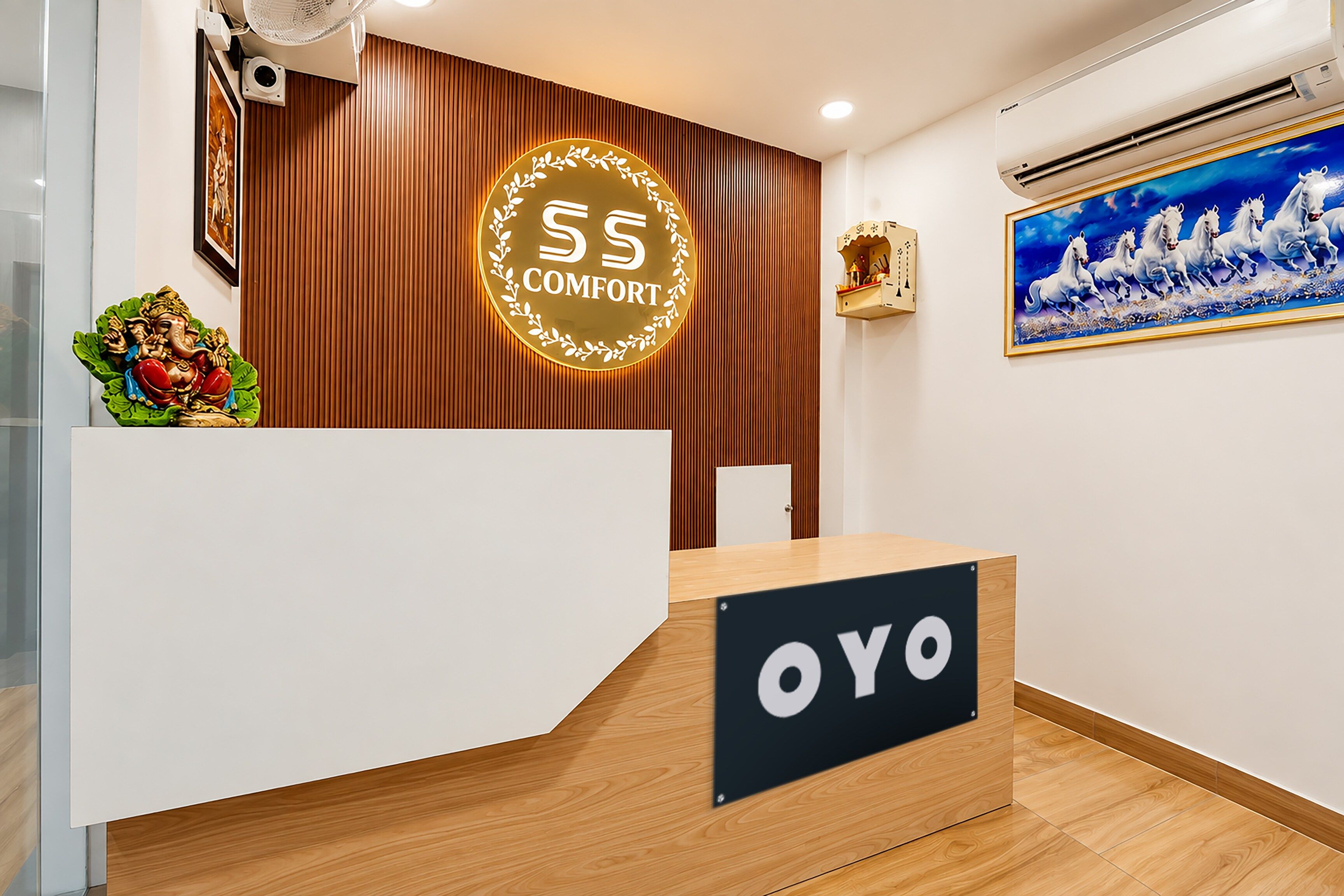Una recepción con un letrero que dice 'OYO' y un emblema circular encima.