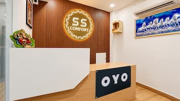 Una recepción con un letrero que dice 'OYO' y un emblema circular encima.