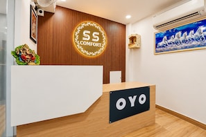 Una recepción con un letrero que dice 'OYO' y un emblema circular encima.