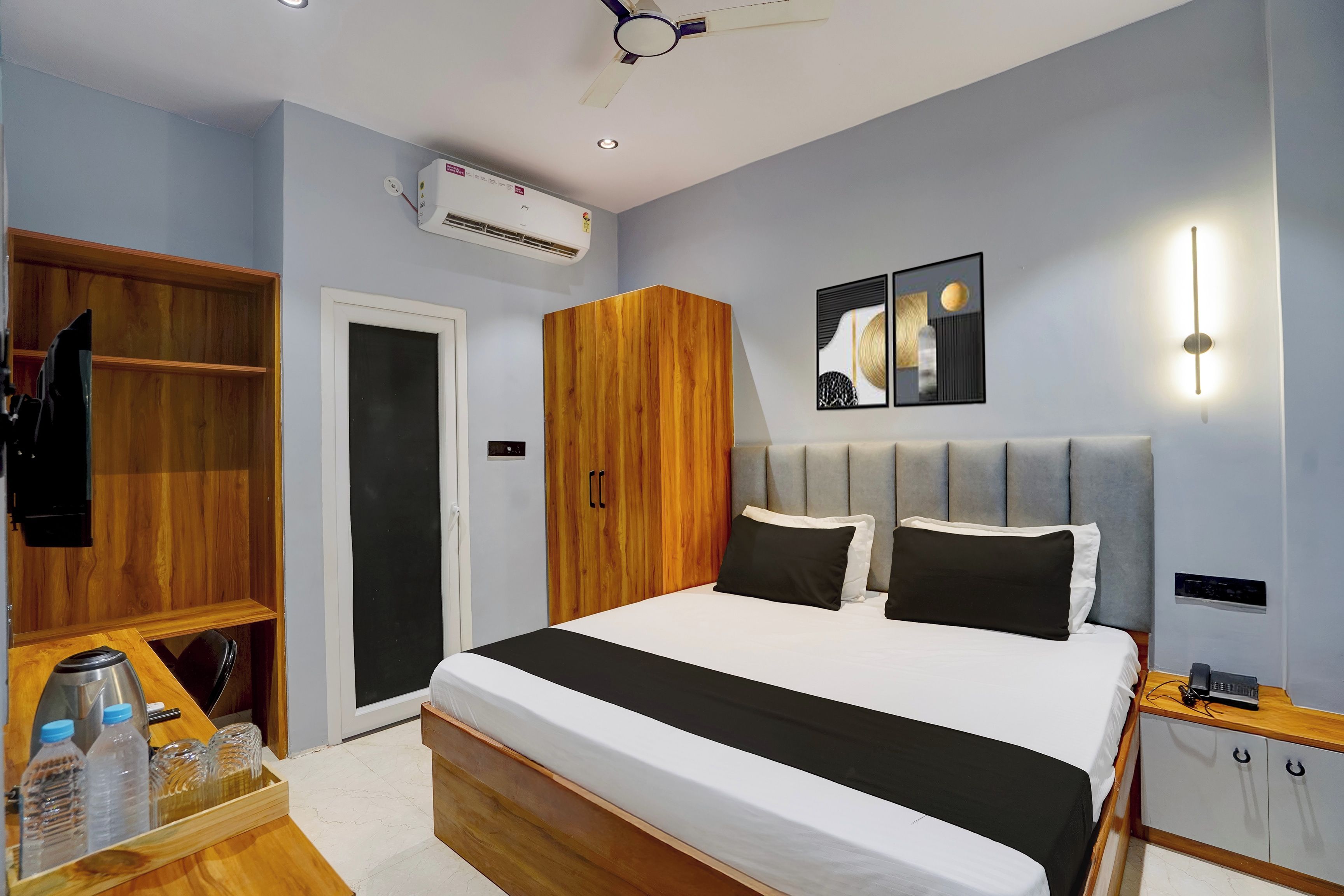 Un dormitorio con cama, armario, mesita de noche y una lámpara de pared.