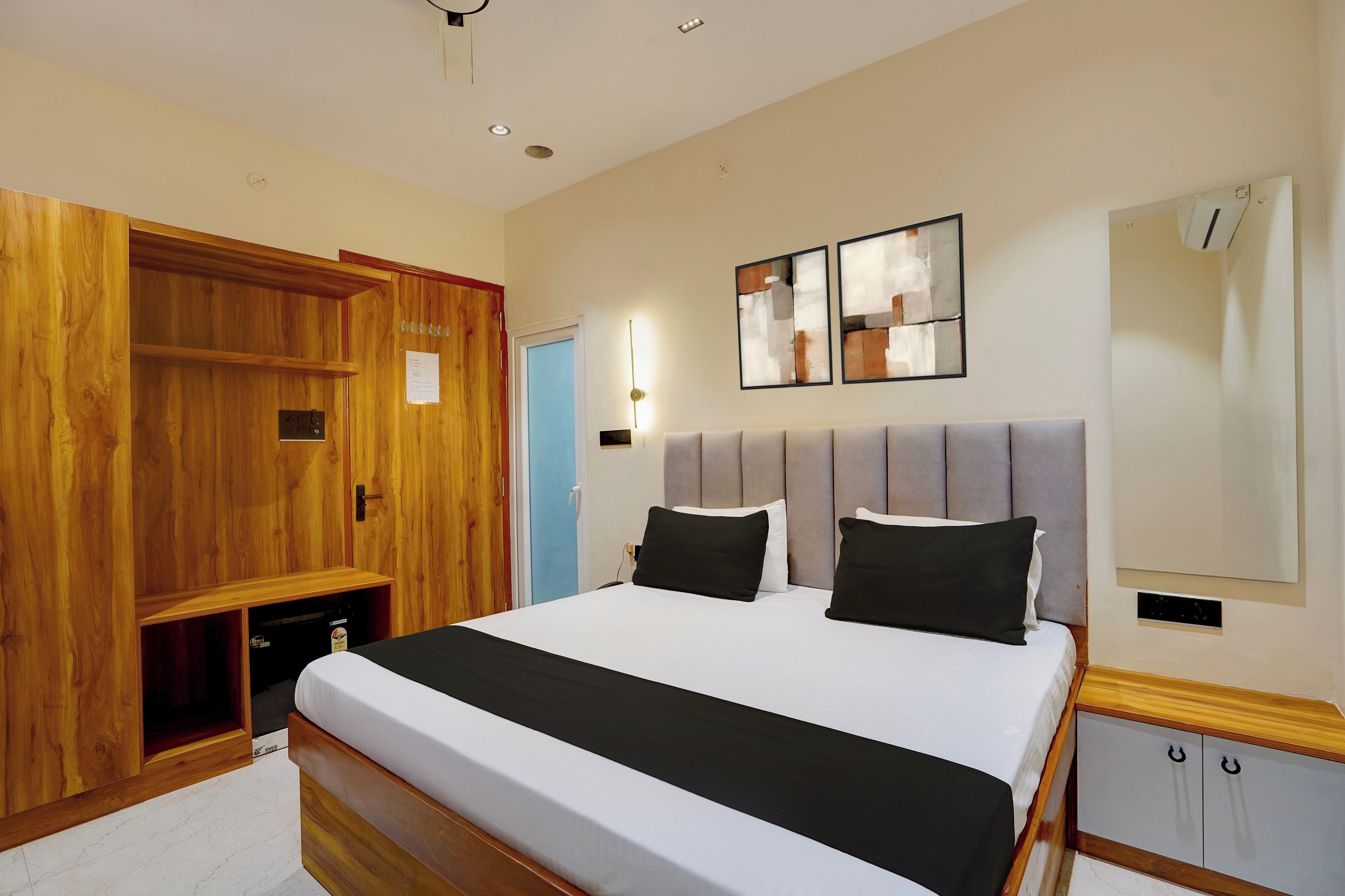 Ein Schlafzimmer mit einem großen Bett, einem Holzschrank und einer Wand-Klimaanlage.