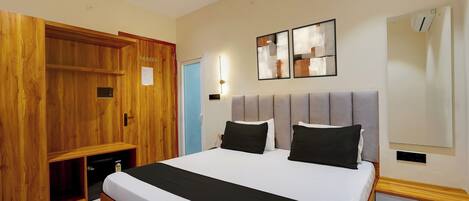 Ein Schlafzimmer mit einem großen Bett, einem Holzschrank und einer Wand-Klimaanlage.