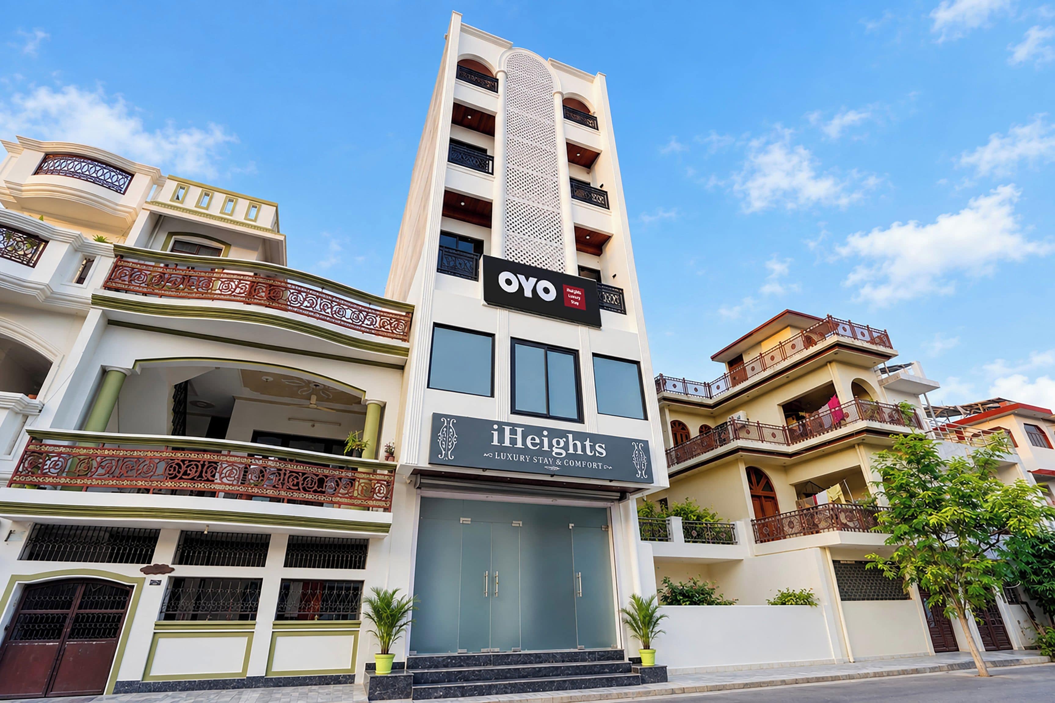 A multi-story hotel with balconies, a central entrance, and signage for 'OYO' and 'iHeights Luxury Stay & Comfort'.