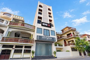 A multi-story hotel with balconies, a central entrance, and signage for 'OYO' and 'iHeights Luxury Stay & Comfort'. - Hotel O iHeights Luxury Stay & Comfort (Lucknow)