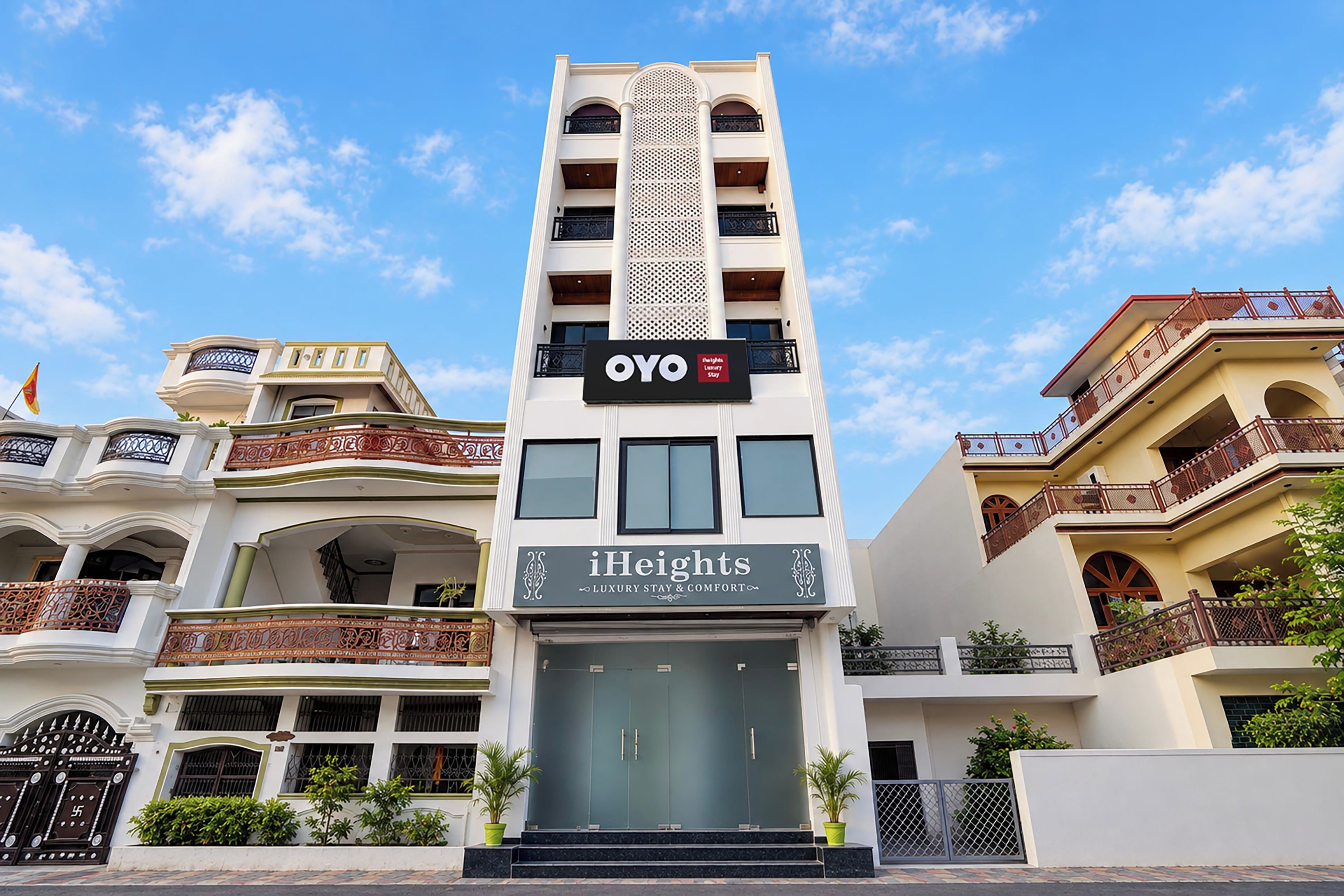 Un hotel de varios pisos con un letrero llamativo que dice 'OYO' e 'iHeights Luxury Stay & Comfort'.