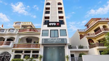 Un hotel de varios pisos con un letrero llamativo que dice 'OYO' e 'iHeights Luxury Stay & Comfort'.