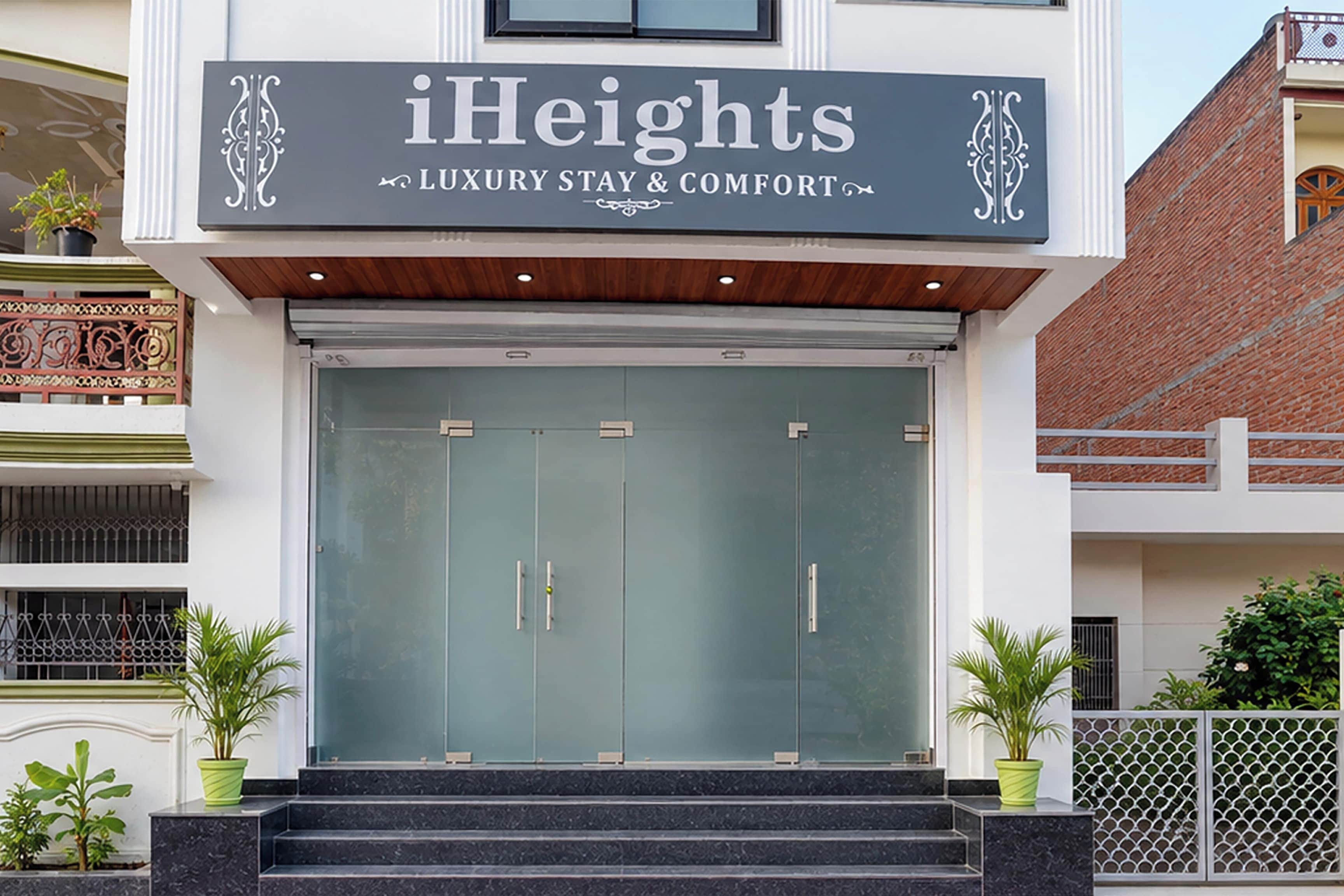 Entrada de un hotel con un cartel que dice 'iHeights Luxury Stay & Comfort'.
