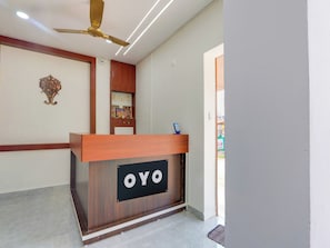 A reception desk with a sign that reads 'OYO' and a ceiling fan above it. - Hotel O Arjun Residency (Khammam)