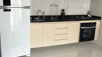 A modern kitchen with a refrigerator, microwave, stove, and dishwasher.
