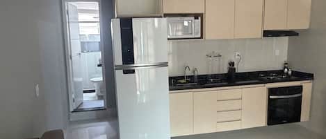 Eine moderne Küche mit Kühlschrank, Mikrowelle, Herd und Spüle.
