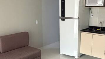 A modern kitchen with a refrigerator, microwave, and sink.