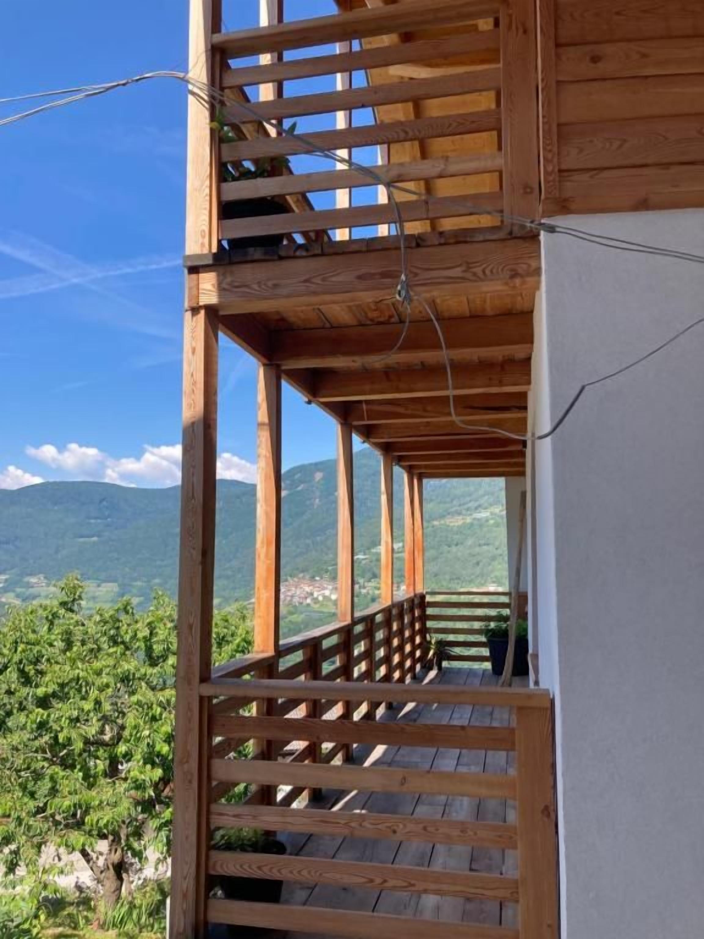 Ein Holzbalkon mit Blick auf eine gebirgige Landschaft.