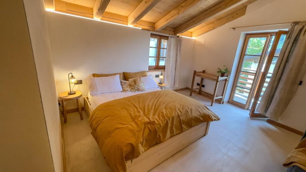 Une chambre à coucher avec un lit, des tables de chevet, un bureau et une fenêtre.