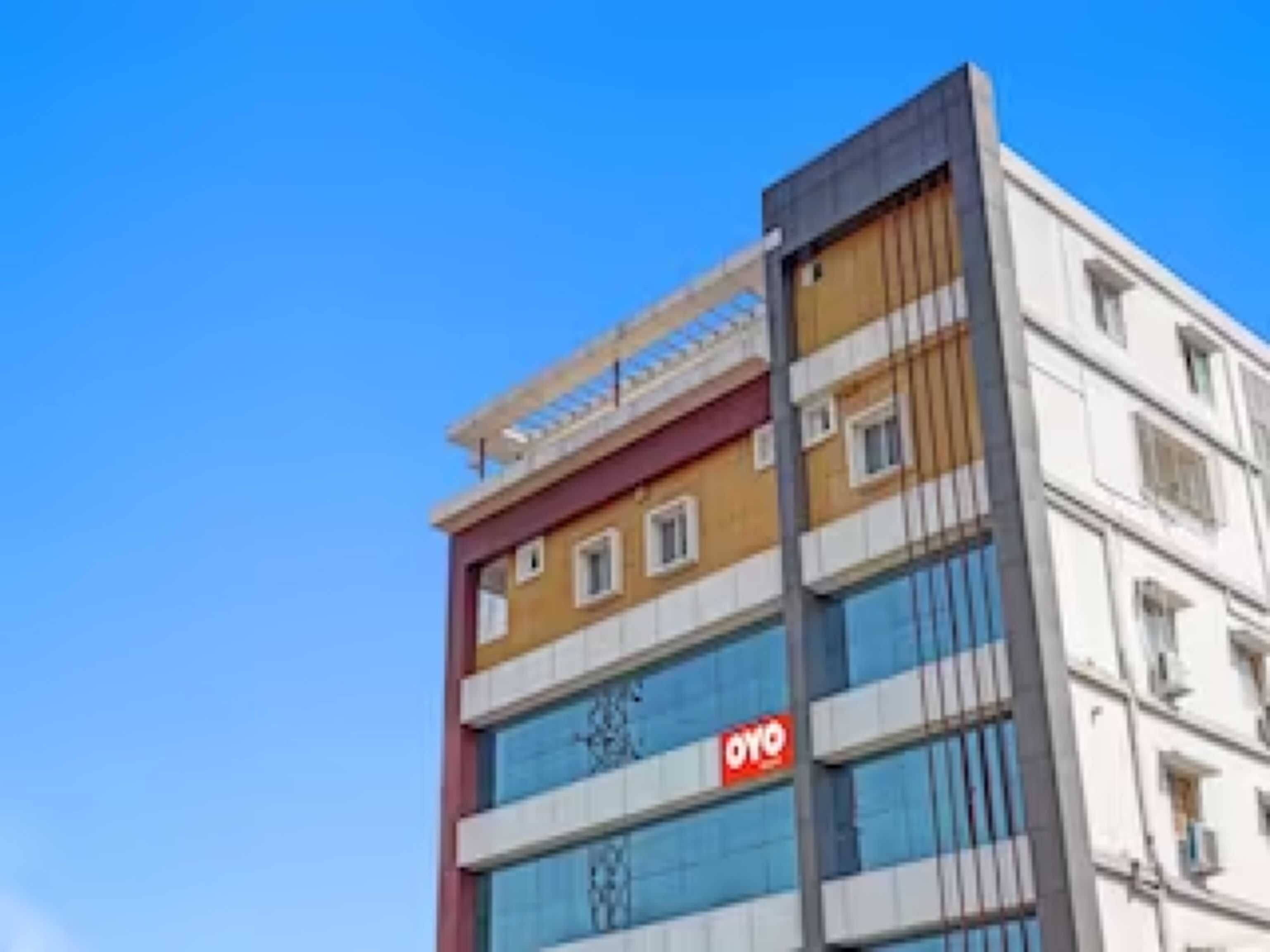 Un edificio de varios pisos con un llamativo letrero 'OYO' en la fachada.