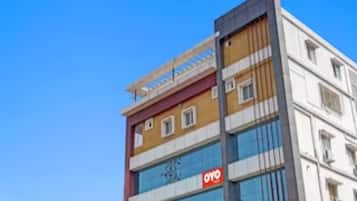 Un edificio de varios pisos con un llamativo letrero 'OYO' en la fachada.