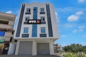 A modern hotel building with a sign indicating it is an OYO Hotel.