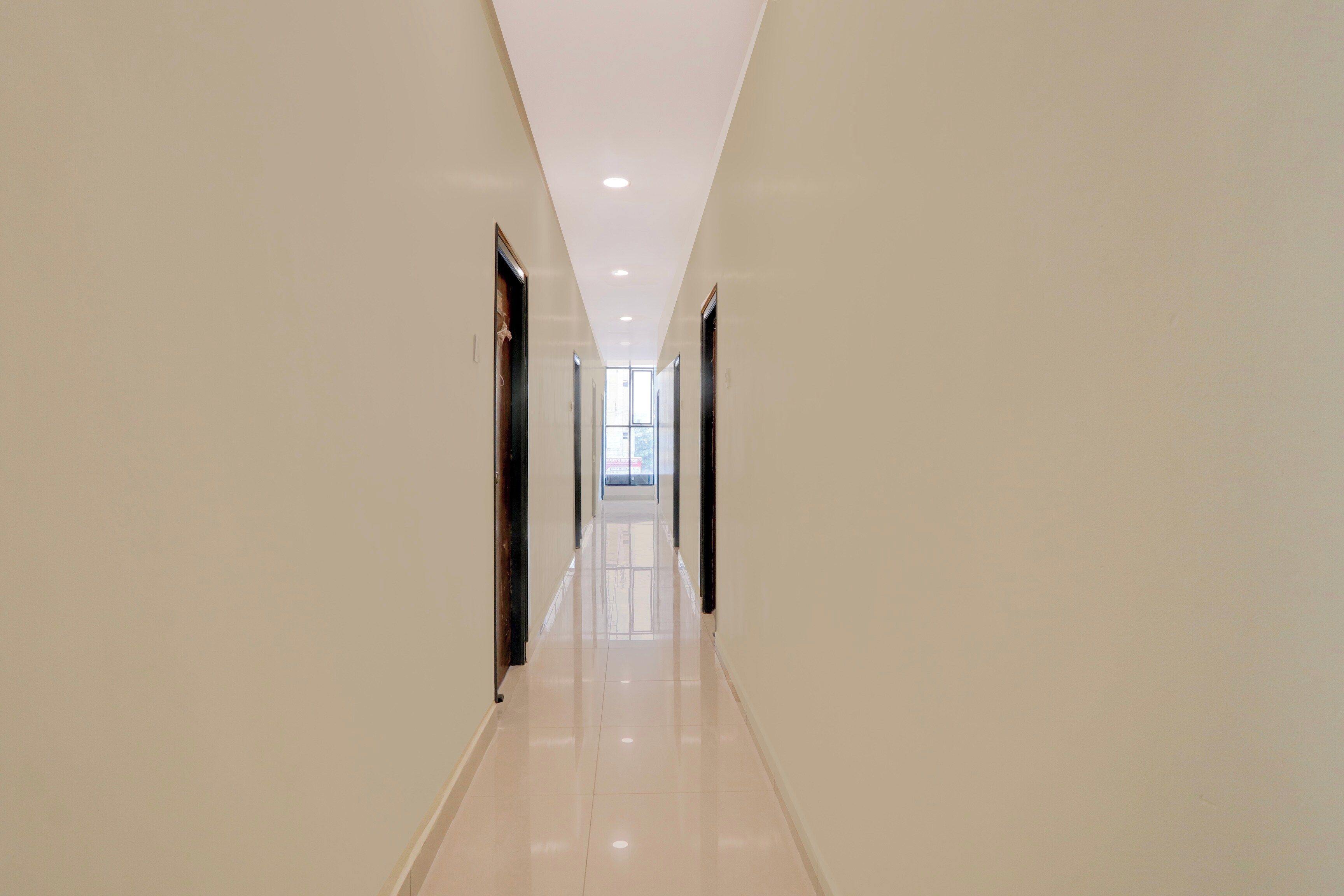 A long, narrow hallway with a glossy floor and doors on both sides.
