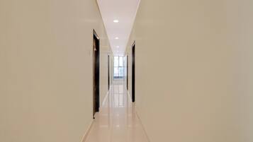 A long, narrow hallway with a glossy floor and doors on both sides.