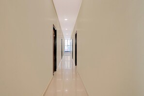 A long, narrow hallway with a glossy floor and doors on both sides. - Super Hotel O RB Classic Inn (Karimnagar)