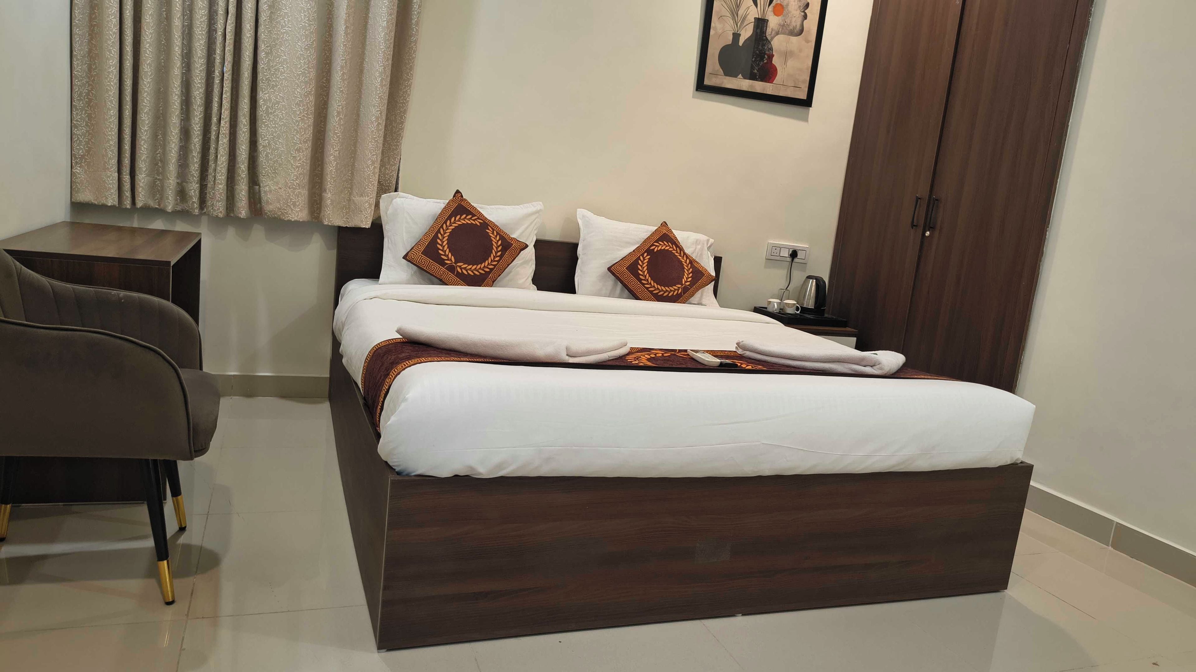 A neatly made bed with a dark wooden frame, white bedding, and decorative pillows.