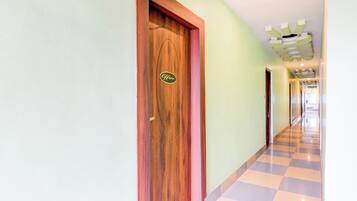 Un pasillo de hotel con una puerta de madera que indica 'Office' y un suelo a cuadros.
