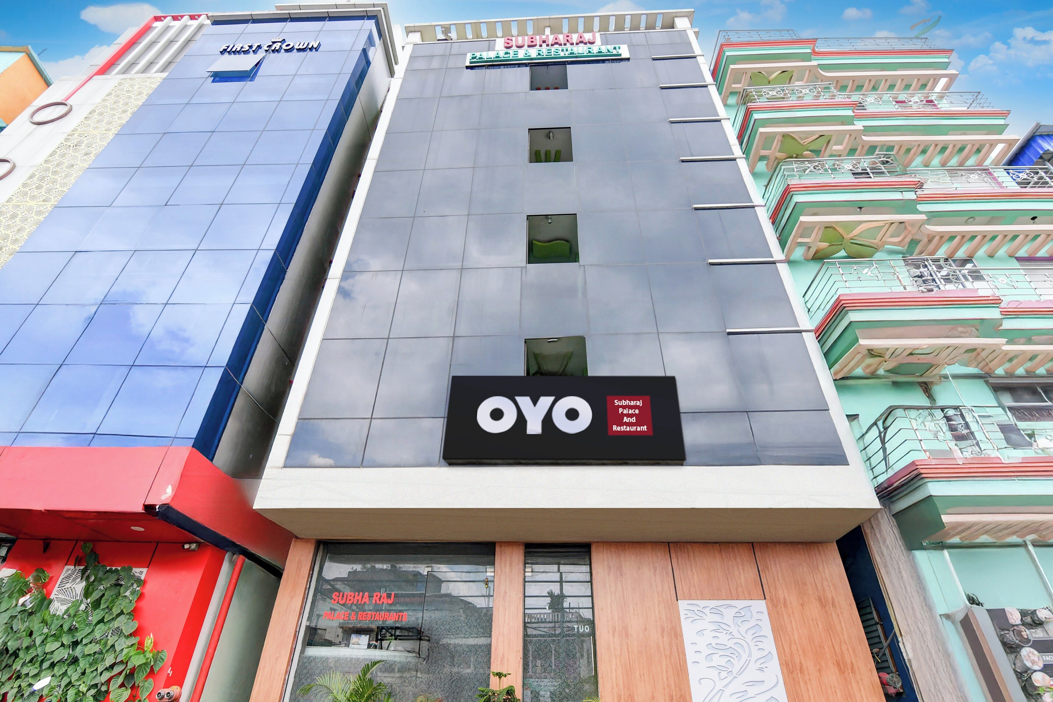 Un edificio de varios pisos con un cartel llamativo para Subharaj Palace & Restaurant.