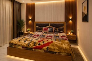 Ein modernes Schlafzimmer mit einem großen Bett, einem Holzkopfstück und einer Steppdecke mit auffälligem Muster.