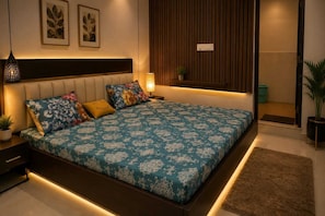 Quarto moderno com cama, mesas de cabeceira, prateleira na parede e planta em vaso.