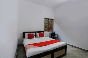 Una camera da letto con un letto, una sedia e una finestra.