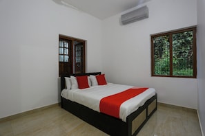 Una camera da letto con un letto, due finestre e un condizionatore d'aria.
