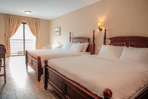 A hotel room with two wooden beds, a balcony with curtains, and a wall-mounted lamp. - The Farmhouse (Ipoh)