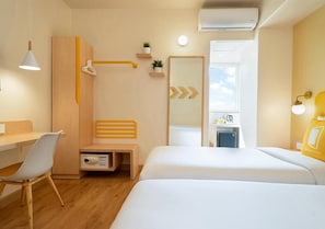 A hotel room with a desk, two beds, a shower, a mirror, and a small kitchenette. - Bloom Hotel - Jayanagar (Bengaluru)