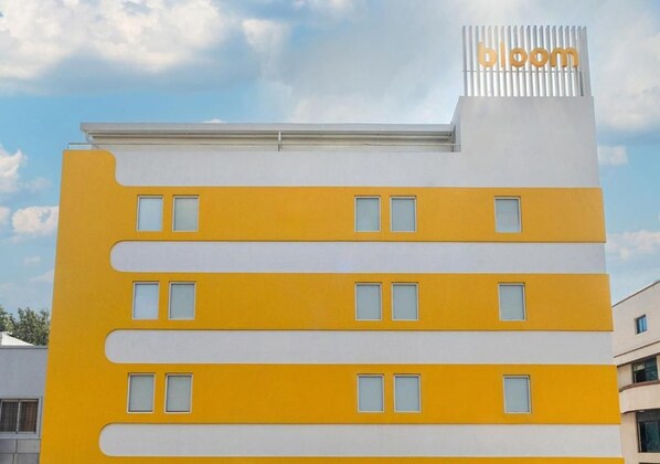 A multi-story building with a yellow facade and a white top section. - Bloom Hotel - Jayanagar (Bengaluru)